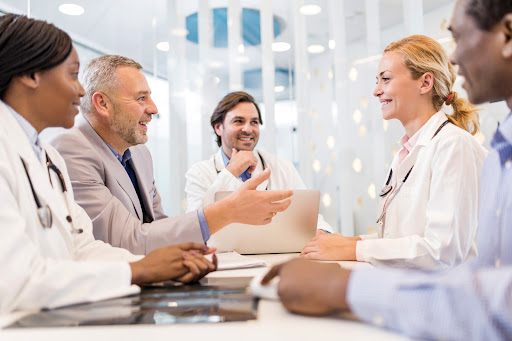 Smiling businessman cooperating with doctors in the hospital.