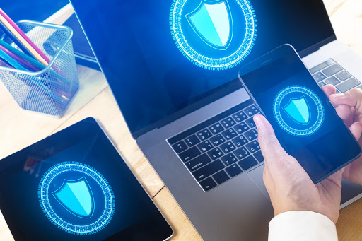 Businessman Using Smart phone to control  Cyber Security with laptop and tablet