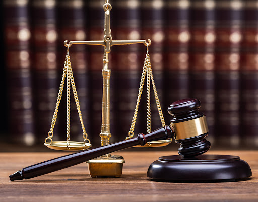 Wooden Gavel With Golden Scale On Table