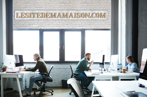 Picture of young colleagues work in office using computers. Looking aside.