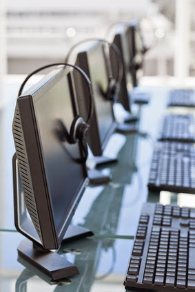Computers and headsets from a call center in line