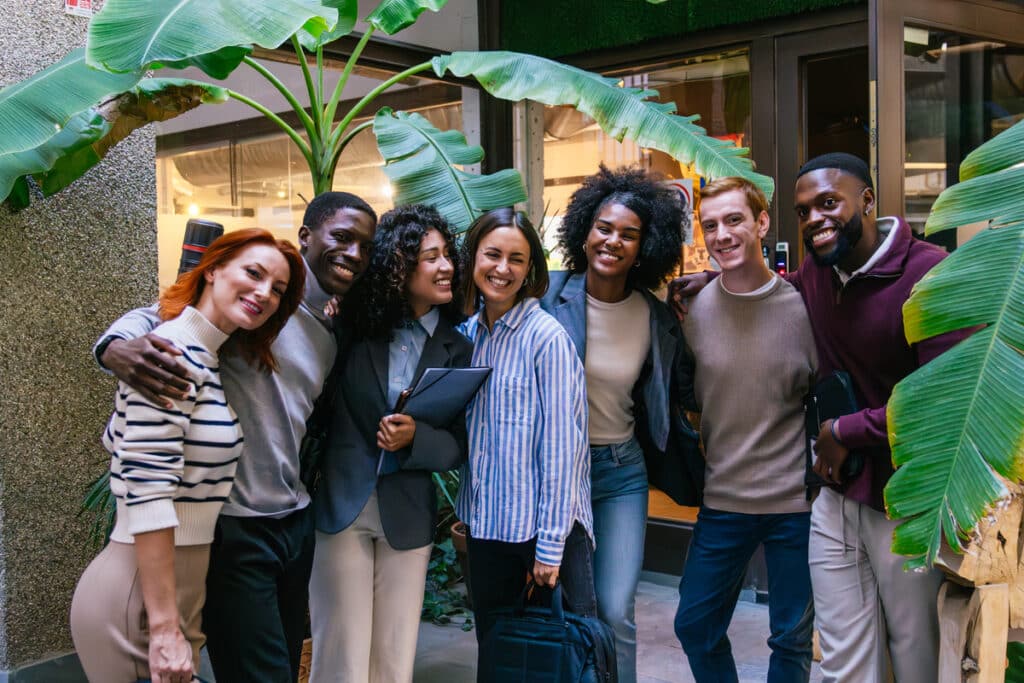 Multiethnic business team smiling together in a modern coworking space, showing teamwork and collaboration