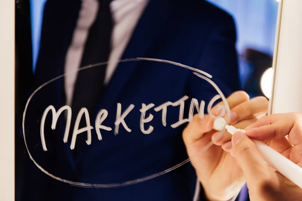 Smart business man writing the word Marketing on the mirror board - Business marketing and branding strategy reminder